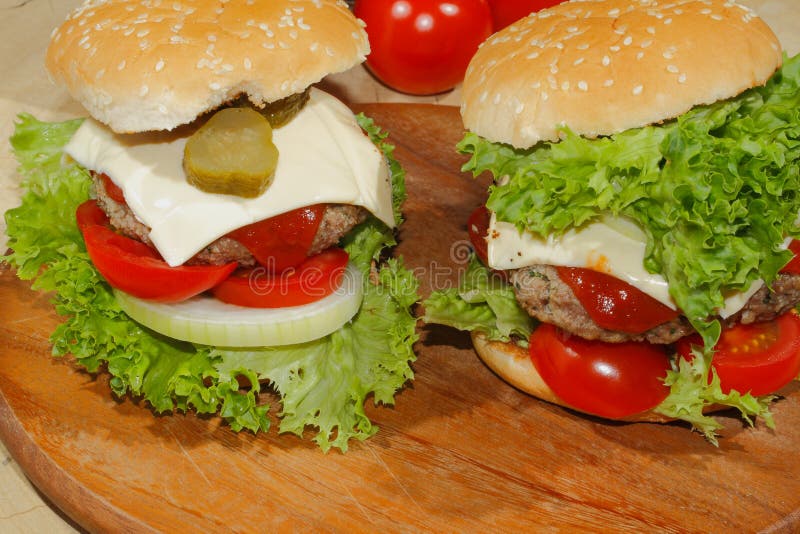 Hamburgers, snel voedsel, hamburger, hamburgerlapje vlees, sla, tomaat, stock afbeelding Hamburgers, snel voedsel, hamburger, hamburgerlapje vlees, sla, tomaat, stock afbeelding