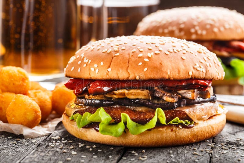 Hamburguer delicioso com as bolas e cerveja fritadas da batata fotos de stock royalty free Hamburguer delicioso com as bolas e cerveja fritadas da batata fotos de stock royalty free