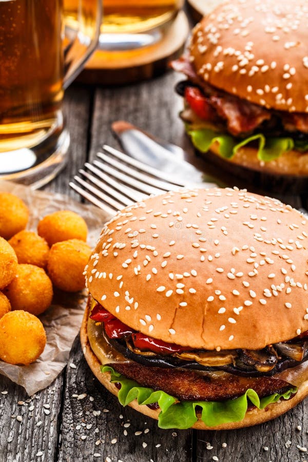 Hamburguer delicioso com as bolas e cerveja fritadas da batata foto de stock Hamburguer delicioso com as bolas e cerveja fritadas da batata foto de stock