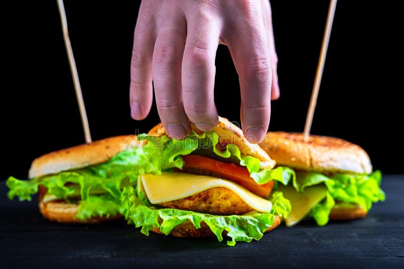 Hamburguesa apetitosa y fresca en una tabla negra de madera, haciendo publicidad de la bandera foto de archivo Hamburguesa apetitosa y fresca en una tabla negra de madera, haciendo publicidad de la bandera foto de archivo