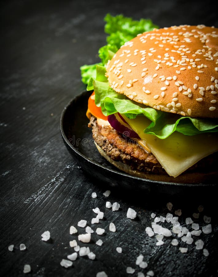 Hamburguesa con queso, la chuleta de la carne y las verduras fotos de archivo libres de regalías Hamburguesa con queso, la chuleta de la carne y las verduras fotos de archivo libres de regalías
