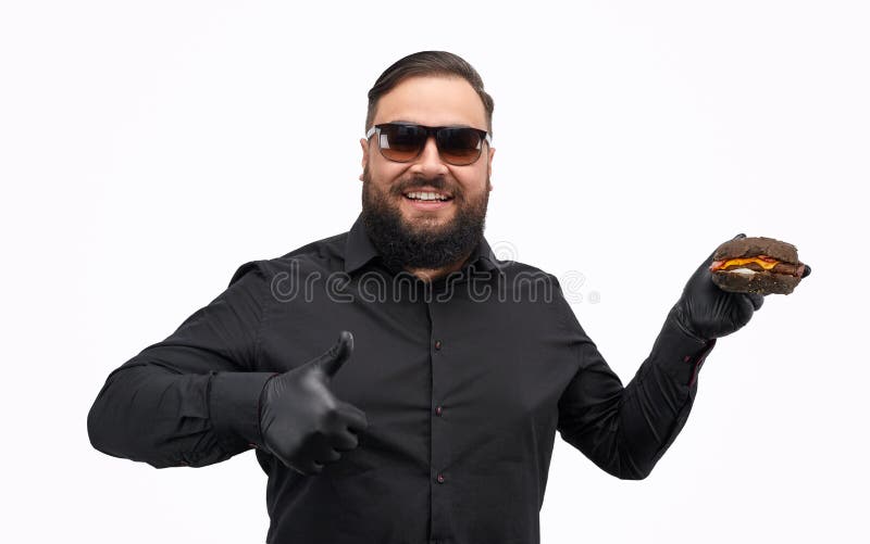 Hamburguesa de la demostración del hombre y el gesticular pulgar gordos para arriba imagen de archivo libre de regalías Hamburguesa de la demostración del hombre y el gesticular pulgar gordos para arriba imagen de archivo libre de regalías