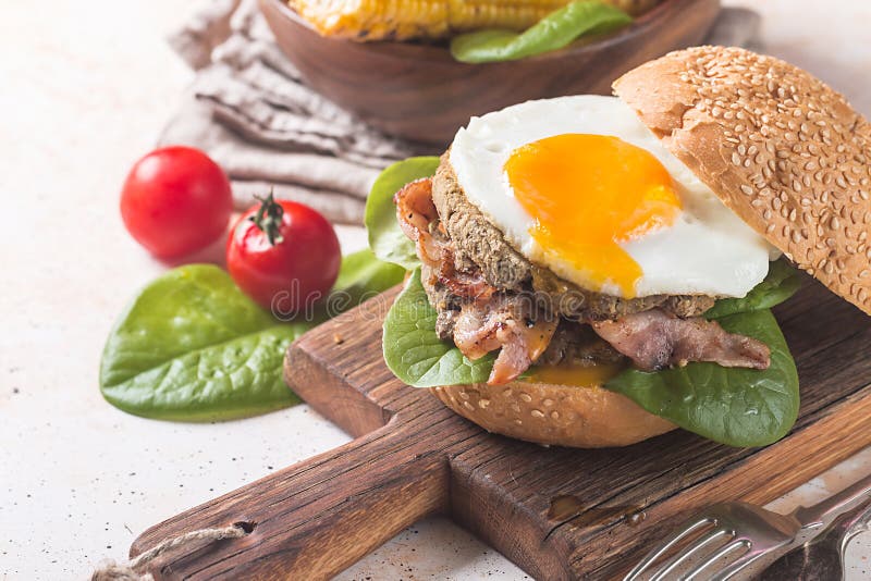 Hamburguesa del tocino de Homemmade con el huevo frito imagen de archivo Hamburguesa del tocino de Homemmade con el huevo frito imagen de archivo