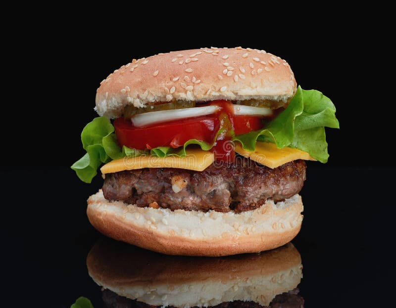 Hamburguesa deliciosa con carne de vaca con queso, tomates, cebollas, pepinos y tomates y salsa de tomate en un fondo negro y en imagenes de archivo Hamburguesa deliciosa con carne de vaca con queso, tomates, cebollas, pepinos y tomates y salsa de tomate en un fondo negro y en imagenes de archivo