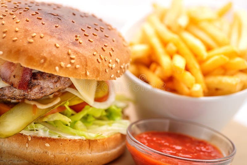Hamburguesa excelente con las patatas fritas y la salsa de tomate en la placa blanca imagen de archivo libre de regalías