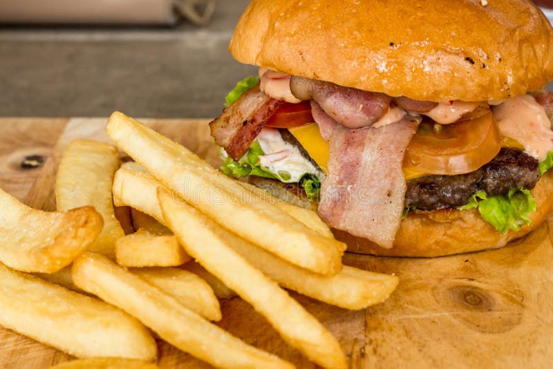 Hamburguesas y patatas fritas en la madera fotografía de archivo libre de regalías Hamburguesas y patatas fritas en la madera fotografía de archivo libre de regalías