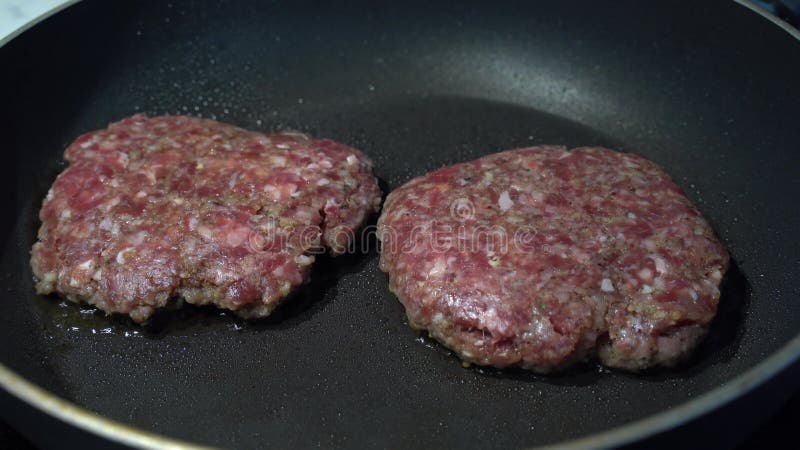 Hambúrgueres cozinhando numa frigideira