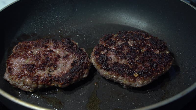 Hambúrgueres cozinhando numa frigideira