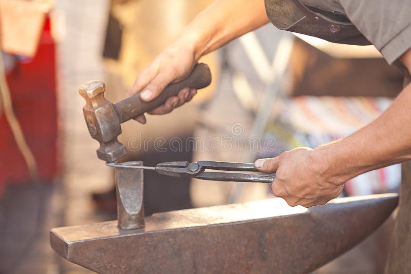 Hammer, anvil and the hands royalty free stock images