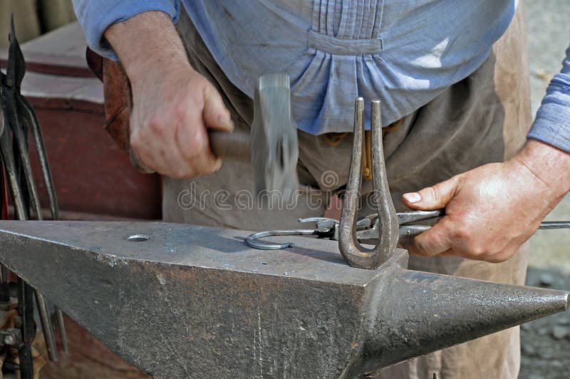 Hammer on Iron -Schmied stock photo