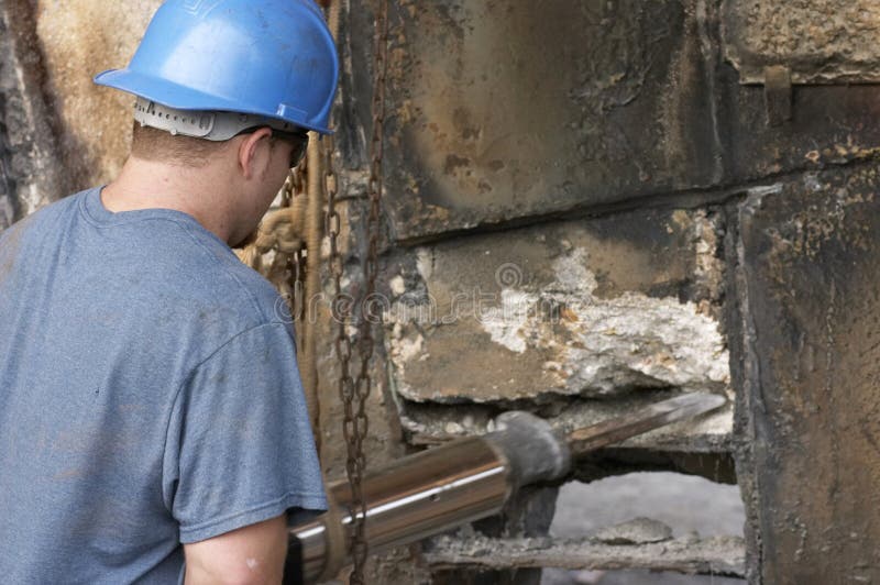 Man using air hammer to bust concrete. Man using air hammer to bust concrete