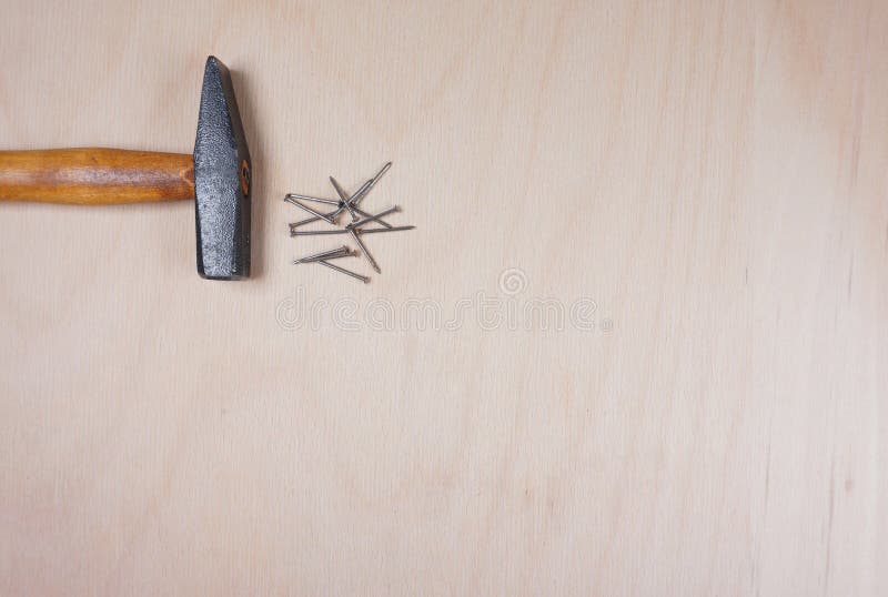 Hammer und N?gel am h?lzernen Hintergrund mit Raum f?r Ihren eigenen Text f?r eine Einladung f?r eine Werkstatt usw. lizenzfreie stockfotos Hammer und N?gel am h?lzernen Hintergrund mit Raum f?r Ihren eigenen Text f?r eine Einladung f?r eine Werkstatt usw. lizenzfreie stockfotos