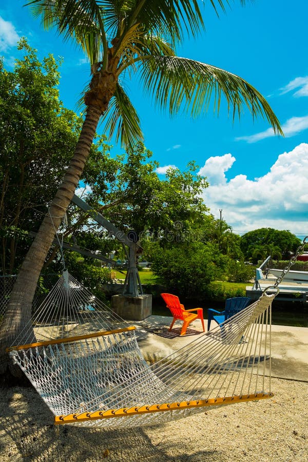 Hammock with Palm Trees on a Beautiful Beach at Sunset Stock Photo
