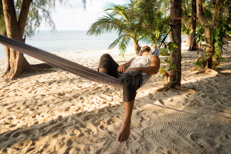 Han ligger i en hammock som njuter av ensamhet och natur som meditativt tillstånd och koncentration royaltyfri foto