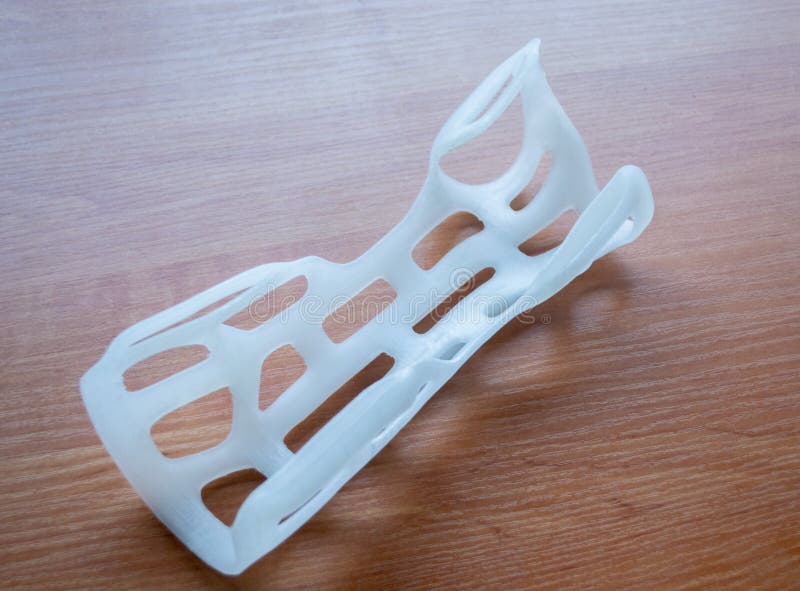 Hand arm splint corset prosthesis printed 3D printer molten plastic on table royalty free stock photos
