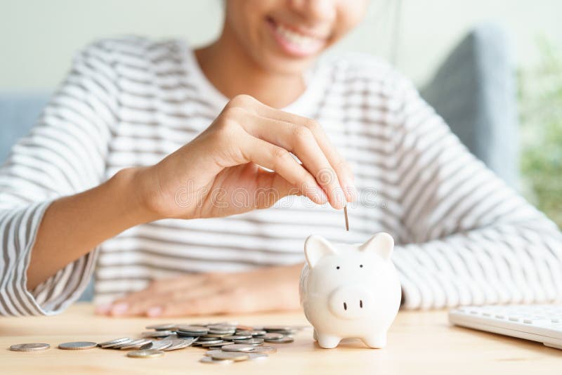 Hand of Asian young girl are putting coins in a piggy bank at home, Close up of child happy smile, retirement, finance and. Saving money for future concept royalty free stock photo Hand of Asian young girl are putting coins in a piggy bank at home, Close up of child happy smile, retirement, finance and. Saving money for future concept royalty free stock photo
