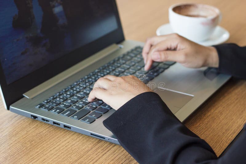 Hand av bruk för affärskvinna en bärbar dator som är funktionsduglig i regeringsställning med varmt kaffe arkivbild Hand av bruk för affärskvinna en bärbar dator som är funktionsduglig i regeringsställning med varmt kaffe arkivbild
