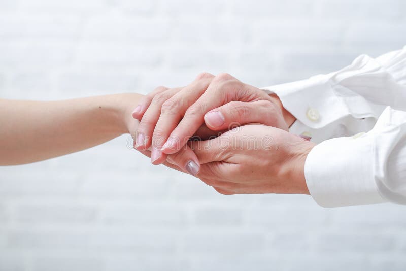 Hand av doktorn som uppmuntrar hennes kvinnliga patient arkivbilder Hand av doktorn som uppmuntrar hennes kvinnliga patient arkivbilder