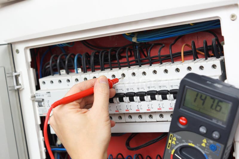 Hand av en elektriker med multimetersonden på en elektrisk strömbrytare arkivbild Hand av en elektriker med multimetersonden på en elektrisk strömbrytare arkivbild