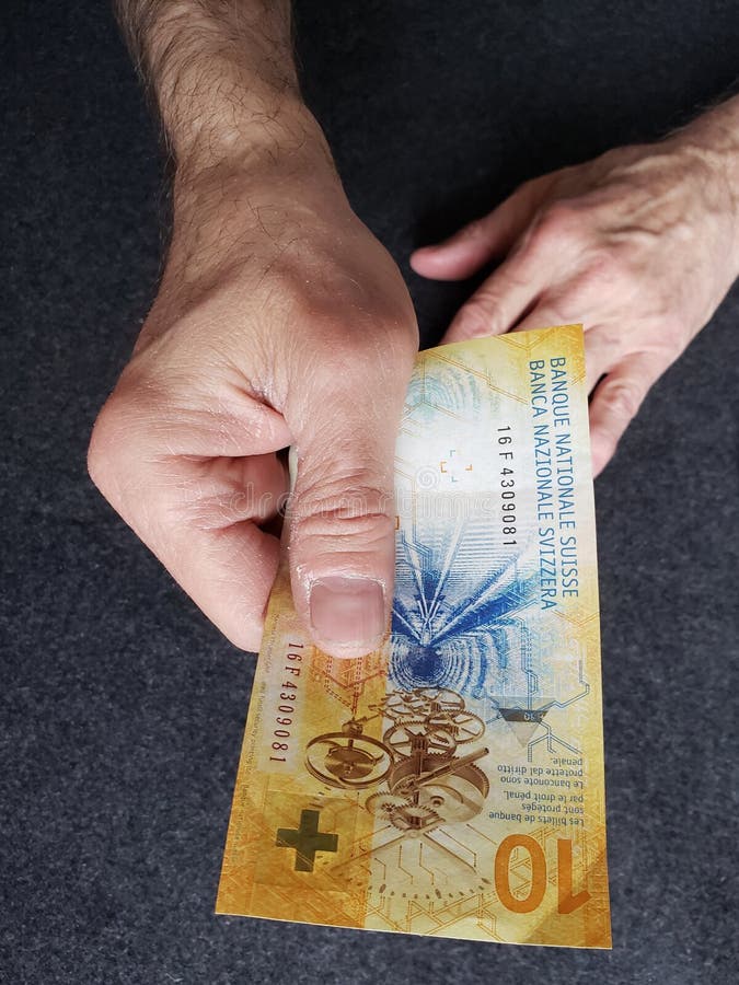 hand av en äldre man som rymmer en schweizisk sedel av tio franc royaltyfri bild hand av en äldre man som rymmer en schweizisk sedel av tio franc royaltyfri bild