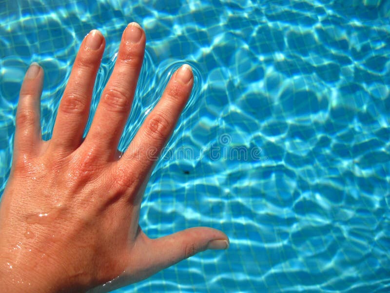 Hand in blue clear water