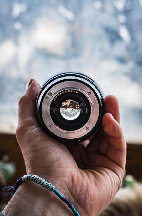 Hand with a bracelet holding a large camera lens royalty free stock photos Hand with a bracelet holding a large camera lens royalty free stock photos