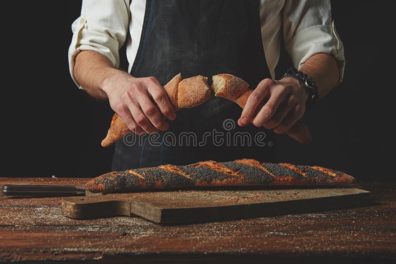 Hand breaks baguette stock image. Image of give ...