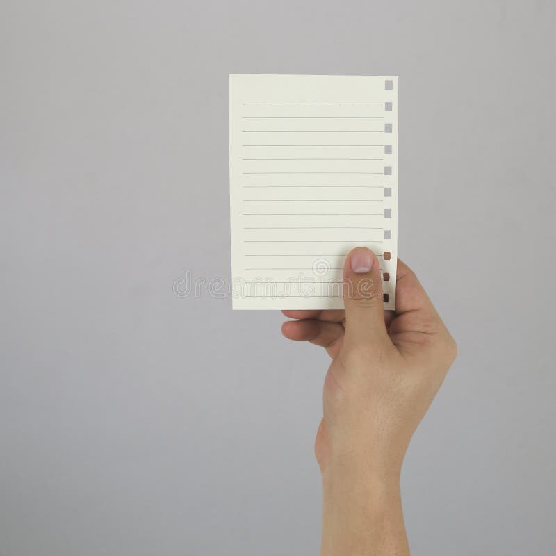 Hand of the businessman holding a empty paper note on gray wall royalty free stock photos