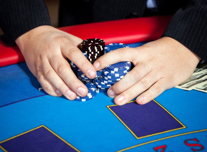 Hand with chips, and $ banknotes on table