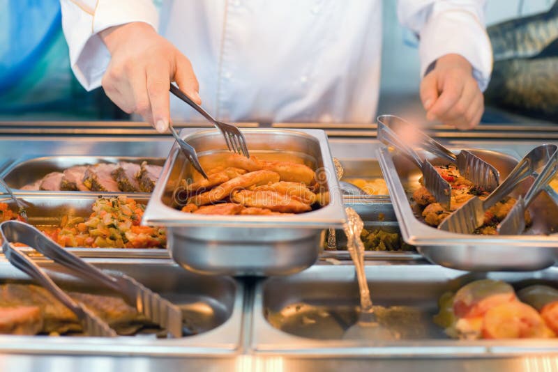 Hand of cook takes nippers fried meat