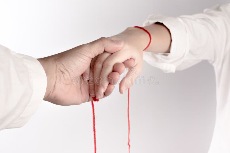 A hand of couple touch each other. The Faith of red thread brings destiny