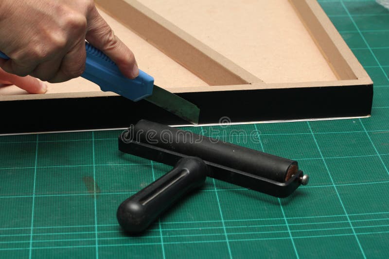 Hand cutter knife cut paper cover on board ,Wood Float Frame with shown in black,side open royalty free stock image Hand cutter knife cut paper cover on board ,Wood Float Frame with shown in black,side open royalty free stock image