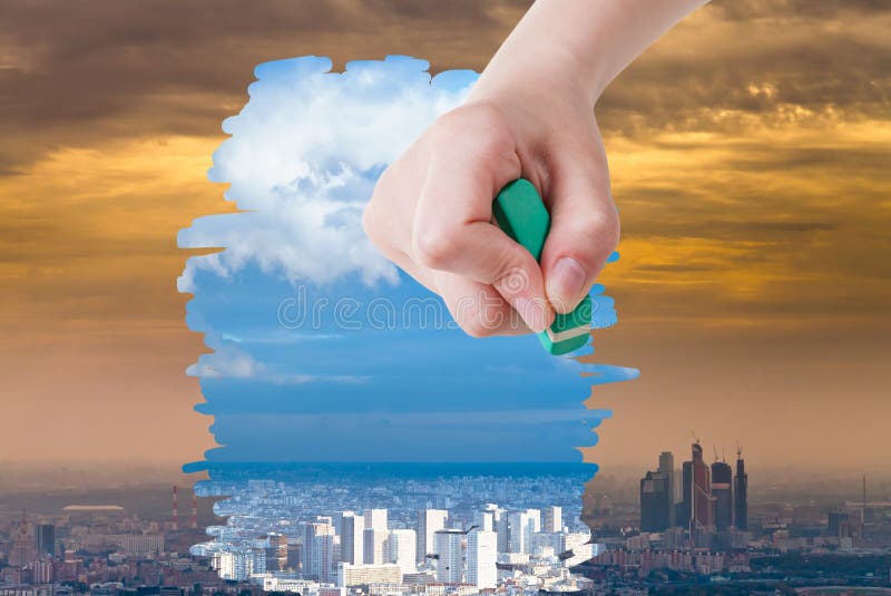 Hand deletes smog urban landscape by eraser