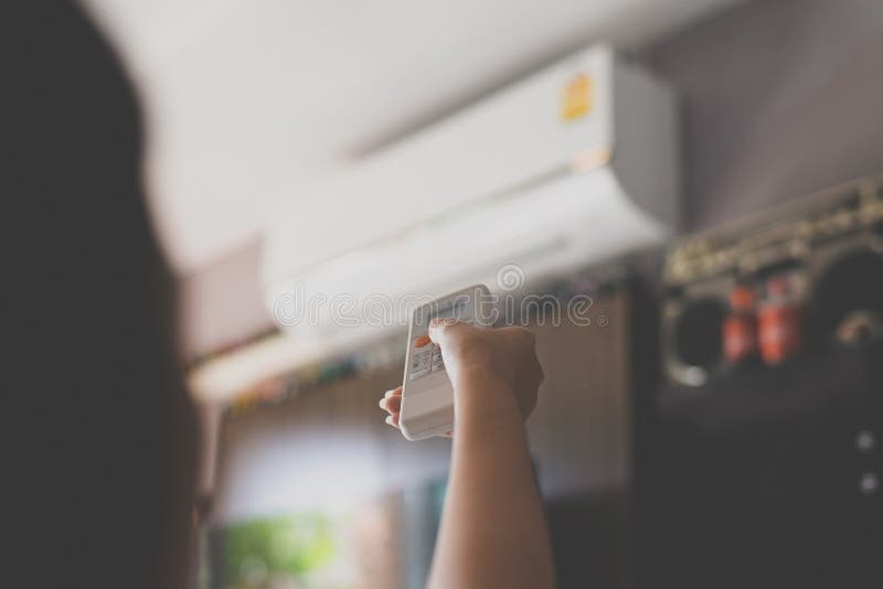 Hand die een afstandsbediening met behulp van aan activerende airconditioning stock afbeeldingen Hand die een afstandsbediening met behulp van aan activerende airconditioning stock afbeeldingen