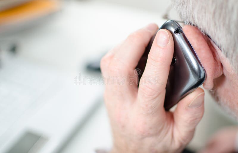 Hand die een mobiele telefoon houdt aan zijn oor stock afbeelding Hand die een mobiele telefoon houdt aan zijn oor stock afbeelding