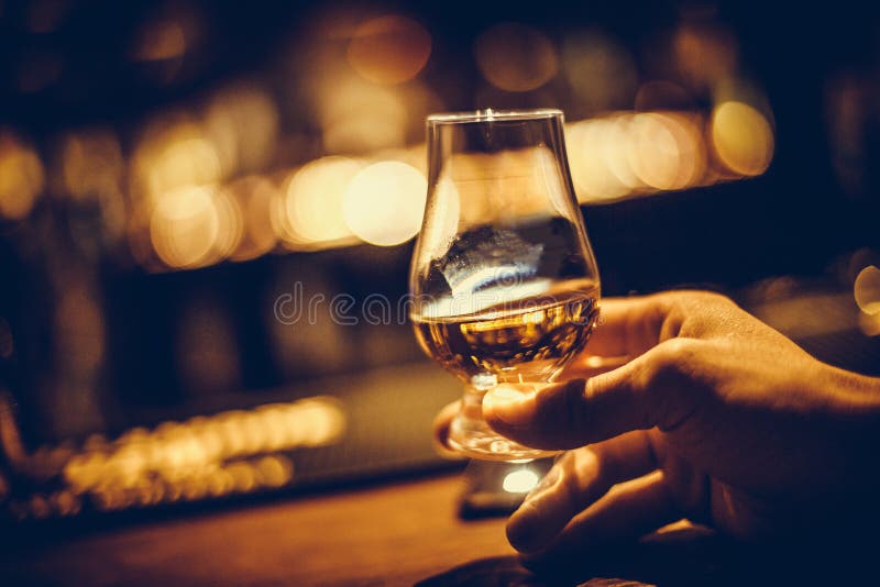 Hand, die ein Malzwhiskyglas Glencairn einzelnes hält