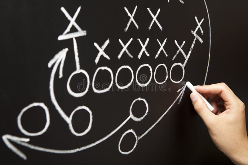Hand, die eine Spielstrategie zeichnet Hand, die eine Spielstrategie zeichnet