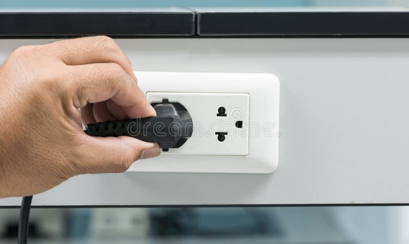 Hand, die einen Stecker von einem Sockel trennt stockbilder Hand, die einen Stecker von einem Sockel trennt stockbilder