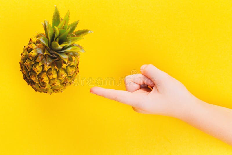 Hand die op ananas in een kader op de zomer gele achtergrond richten royalty-vrije stock foto's Hand die op ananas in een kader op de zomer gele achtergrond richten royalty-vrije stock foto's