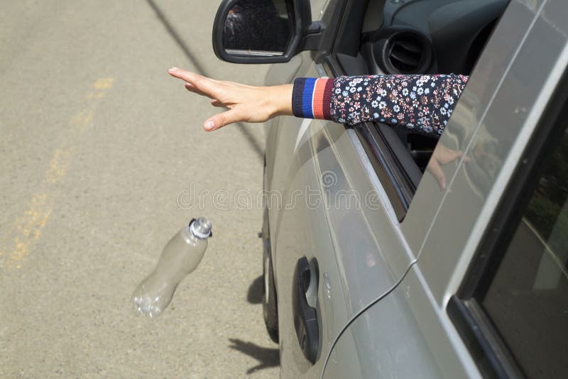 Hand, die Plastikflasche auf der Straße wirft lizenzfreie stockbilder Hand, die Plastikflasche auf der Straße wirft lizenzfreie stockbilder