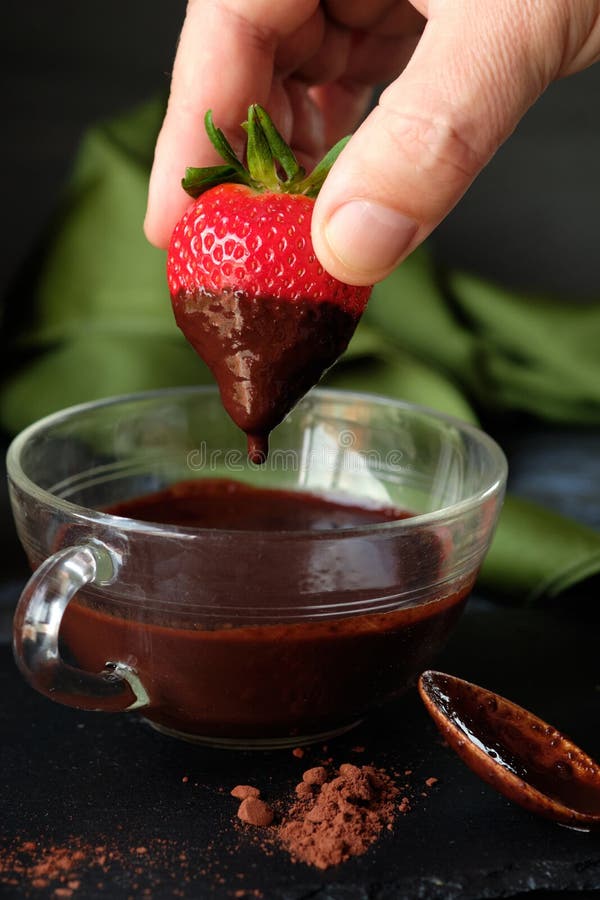 A Hand Dipping a Strawberry into Chocolate Stock Image Image of
