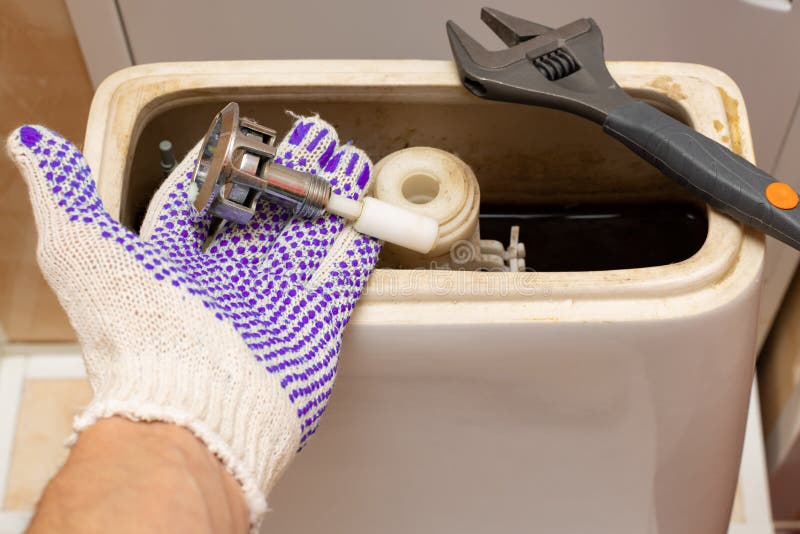 Hand dismantling the flush mechanism of the toilet tank. High quality photo. Cistern button stock images, royalty-free photos and pictures