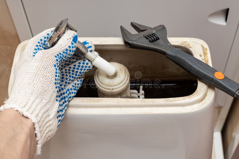 Hand dismantling the flush mechanism of the toilet tank. High quality photo. Cistern button stock images, royalty-free photos and pictures