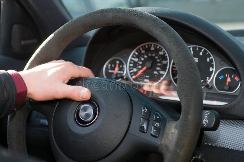 Hand of the driver on a steering wheel.