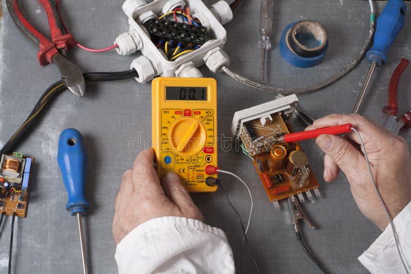 Hand of electrician with multimeter probe at electrical switchgear cabinet. Engineering tools royalty free stock photography Hand of electrician with multimeter probe at electrical switchgear cabinet. Engineering tools royalty free stock photography