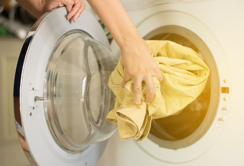 Hands Female Getting in Dirty Clothes into Washing Machine Doing Laundry at House Stock Image