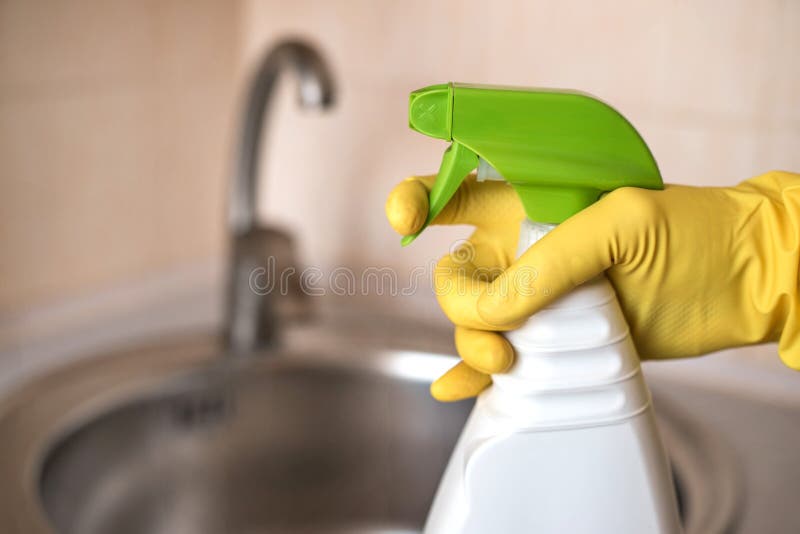 Hand of female janitor with detergent against sink. stock image Hand of female janitor with detergent against sink. stock image