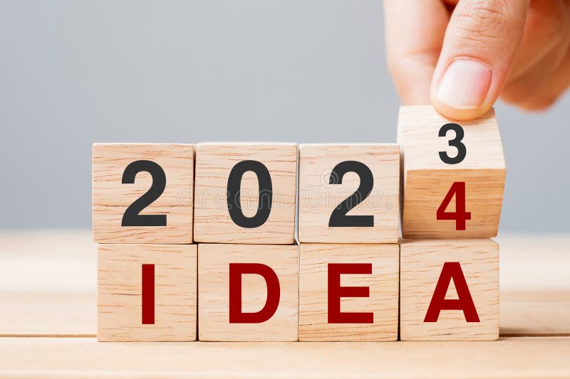 2024 Block Over 2023 and 2022 Wooden Building on Table Background