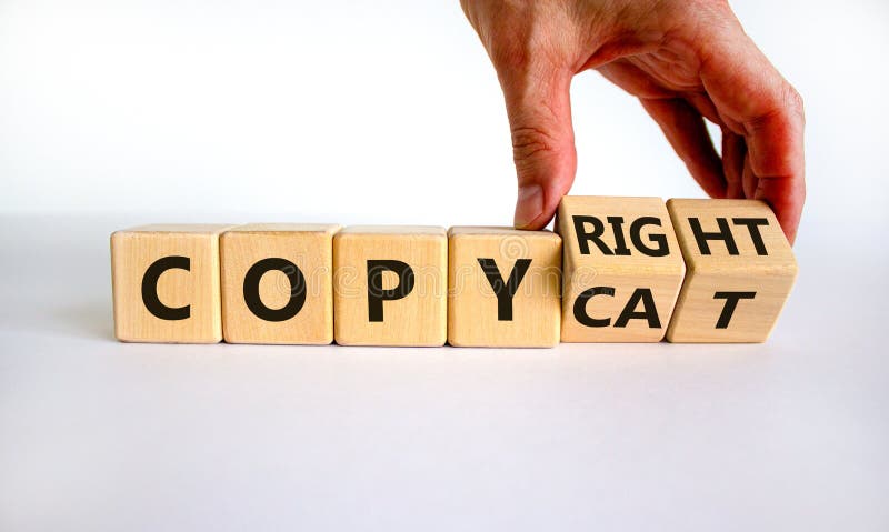 Hand flips cubes and changes the word `copycat` to `copyright`. Beautiful white background. Business concept. Copy space