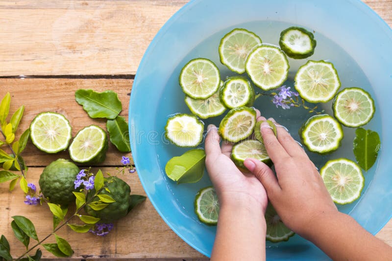 Hand of girl cleaning with kaffir lime slice float on the water royalty free stock photos Hand of girl cleaning with kaffir lime slice float on the water royalty free stock photos